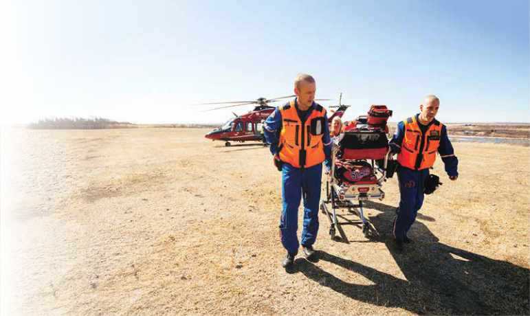 Stars paramedics pulling stretcher from helicopter on sand