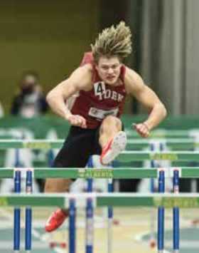 Kayden Johnson jumping hurdles at indoor track field