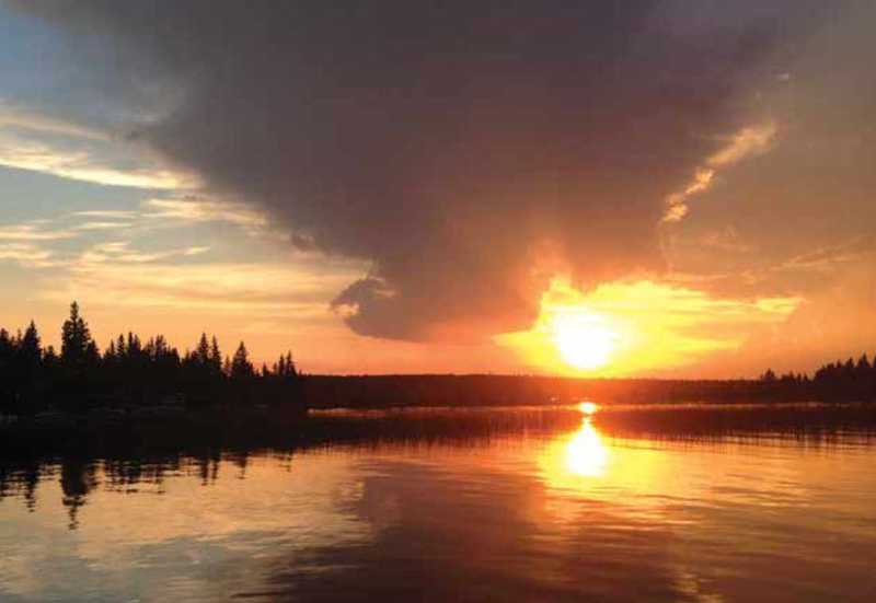 Sunset over a forested lake